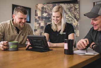 FBN employees at table using tablet